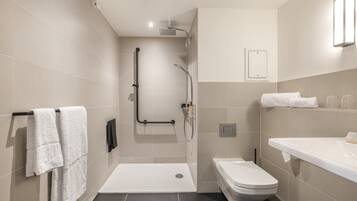 A modern bathroom with a shower, toilet, and sink.