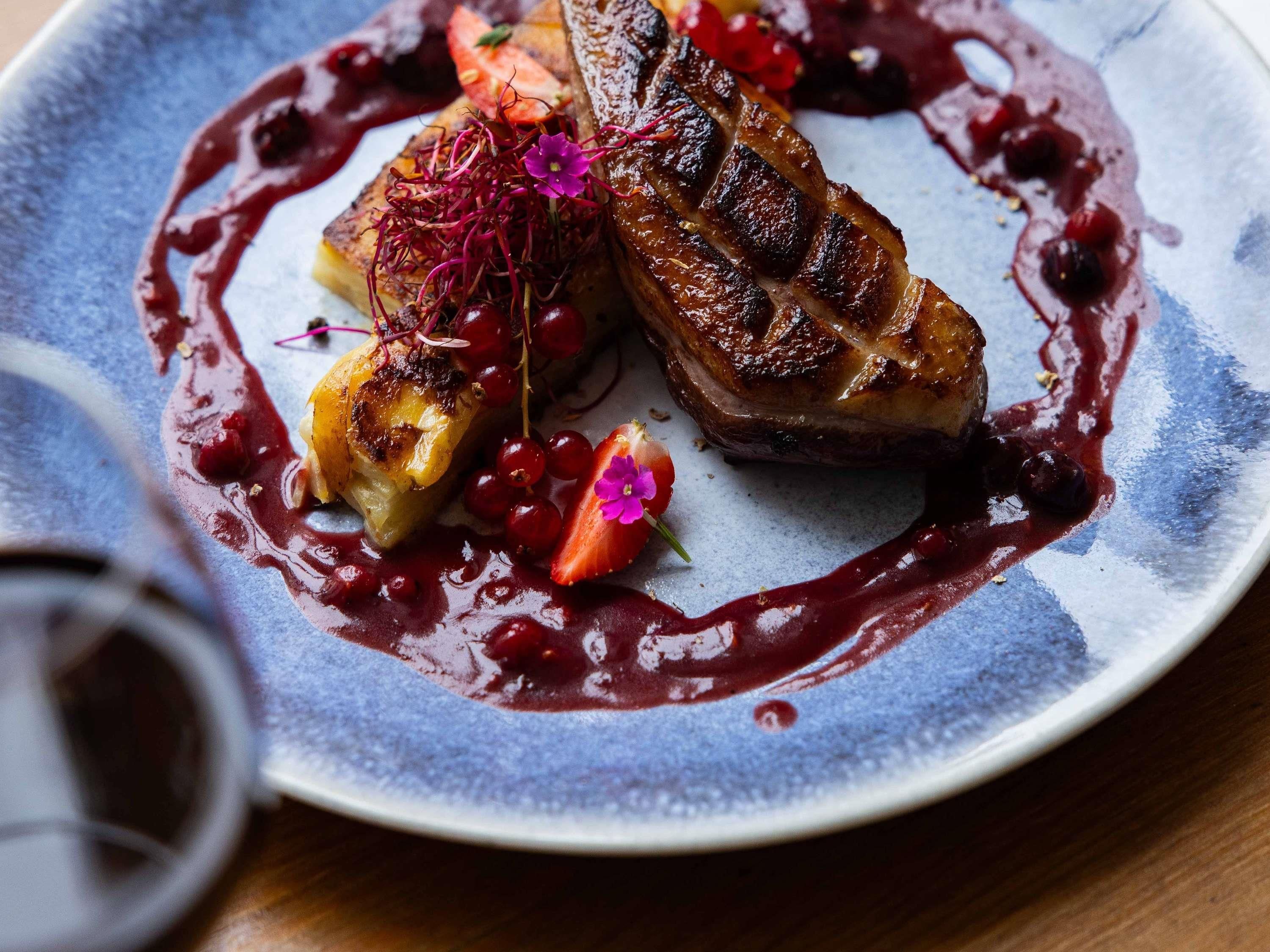Une assiette de nourriture accompagnée d’un verre de vin rouge.