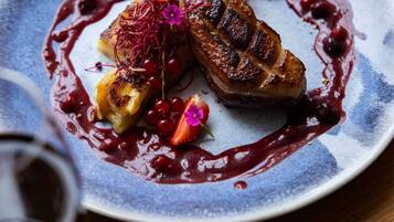 Une assiette de nourriture accompagnée d’un verre de vin rouge.