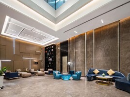A modern interior with a seating area, bookshelves, and a decorative glass table.
