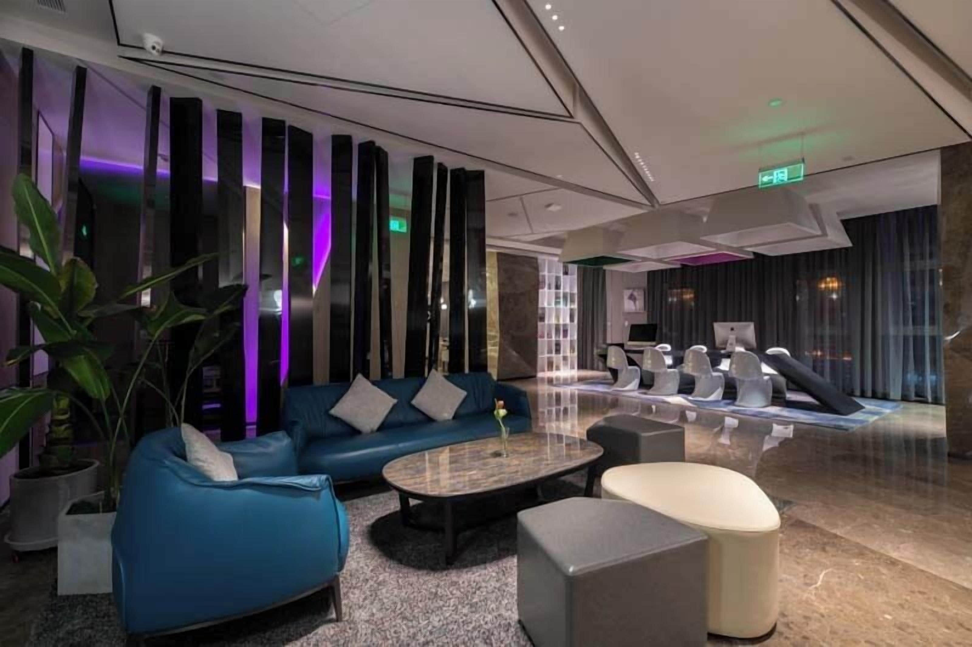 Een moderne lobby met een blauwe bank, een bijzettafeltje en een receptiebalie.