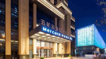 A hotel entrance with a prominent sign, large glass doors, and a modern building facade.
