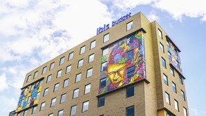 A hotel with multiple floors, large windows, and colorful murals on the exterior walls. - ibis Budget Bogota Marly (Bogotá)