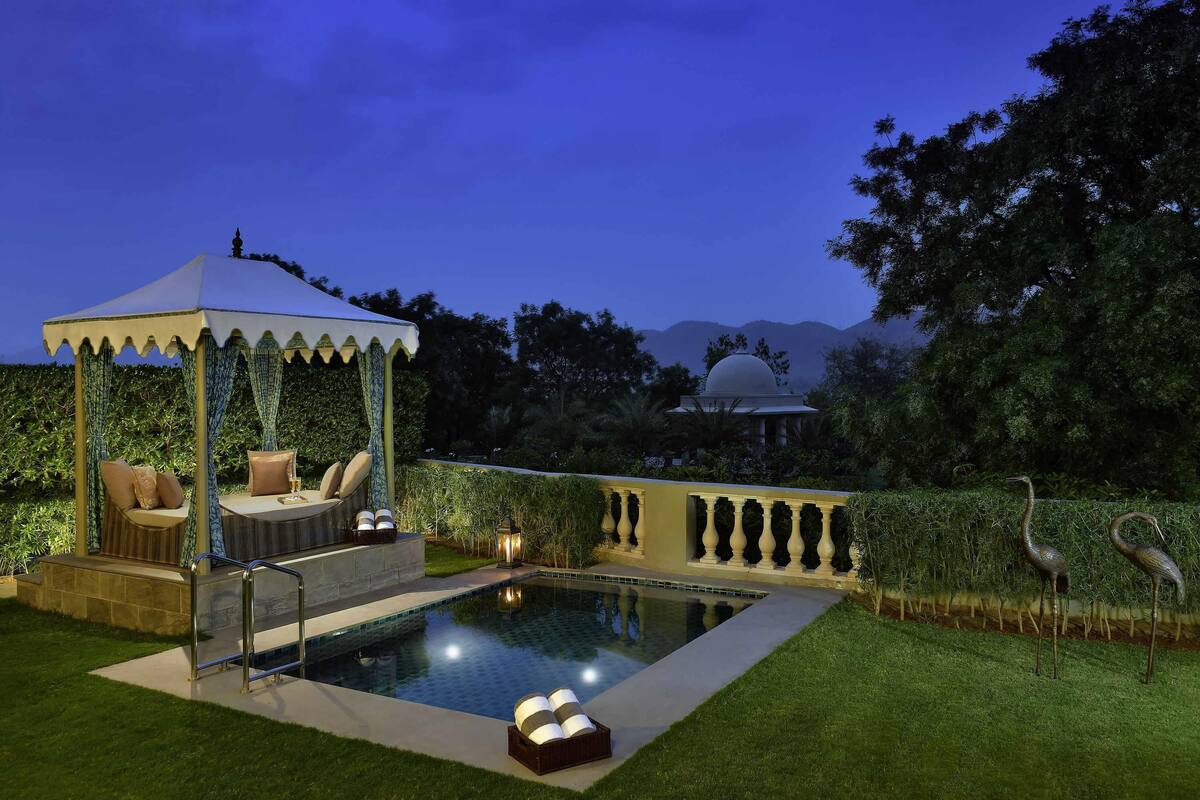 Zona de piscina con un pabellón, asientos y vistas a montañas.