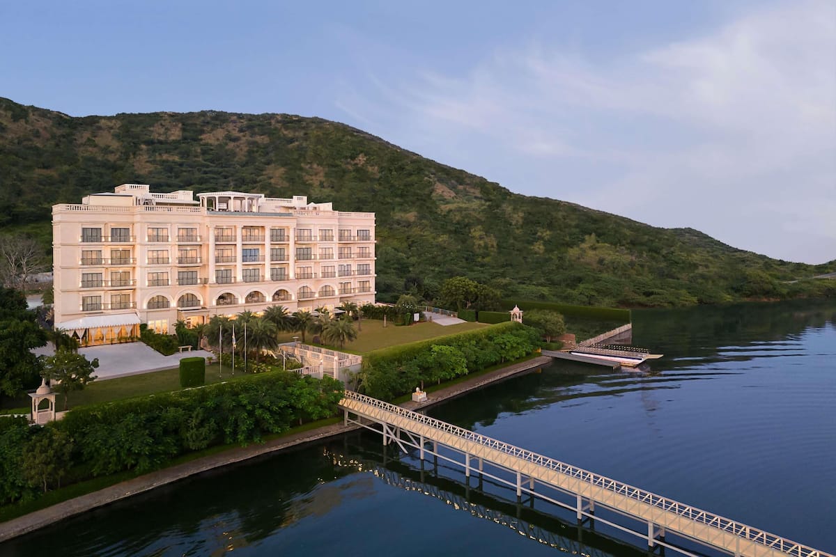 A large hotel with multiple floors, a bridge, and a body of water.