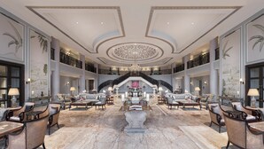 A grand lobby with a central staircase, multiple seating areas, and a chandelier. - Raffles Udaipur (Udaipur)