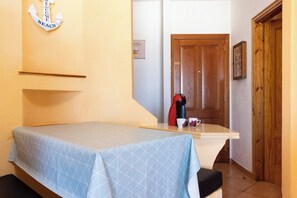 Une petite pièce avec un lit, une machine à café et une porte en bois.