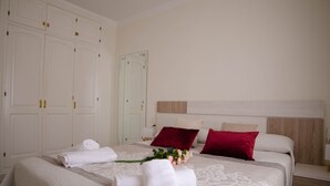 A neatly arranged hotel room with a large bed, a wooden headboard, and a wardrobe with multiple doors.