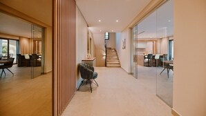 A modern hotel interior with a central staircase, glass walls, and a dining area with contemporary furniture. - Gorgeous Villa Luana with wellness and pool (Malinska)