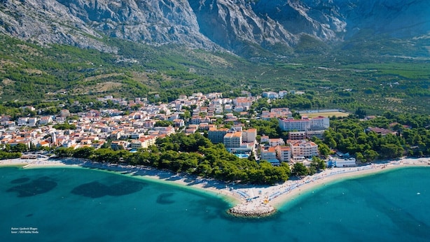 An aerial view of a coastal town with buildings, a beach, and mountains in the background. - Stone villa Judita with heated pool and hydro-massage, Billiard Room (Makarska)
