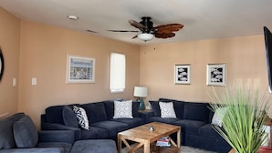 A living room with a dark blue sofa set, a wooden coffee table, and a ceiling fan. - Close to everything! Short walk to beach, boardwalk and restaurants (Wildwood)