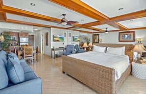 A spacious bedroom with a large bed, a dining area, and a kitchen.