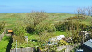 A rural landscape with a grassy field, a wooden fence, and a bench. - Great sea views, close to a small beach and Flamborough Head lighthouse. (Flamborough)