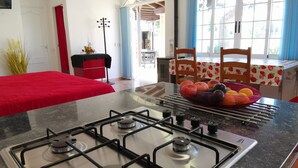 Una cocina moderna con estufa a gas, una mesa de comedor con sillas y vistas al exterior a través de amplios ventanales.