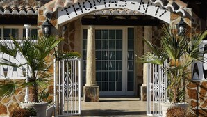 Entrada de un edificio de piedra con un letrero que dice "THOMAS-MY" y dos portones que conducen a una puerta.