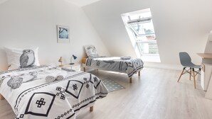 Une chambre avec deux lits, un bureau et une chaise.