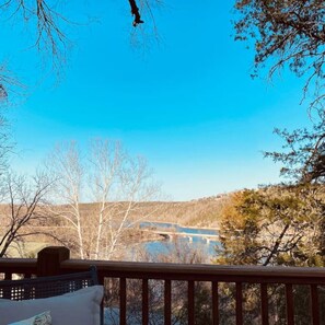 Eine Terrasse mit Blick auf einen Fluss und Bäume.