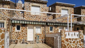 A stone building with a gated entrance, a small window, and a door. - Terraced apartment André A3 by the sea (Els Poblets, Comunidad Valenciana)