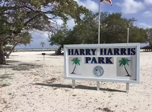 Harry Harris -puiston opastekyltti, jossa on palmujen kuvakkeita ja pyöreä logo.