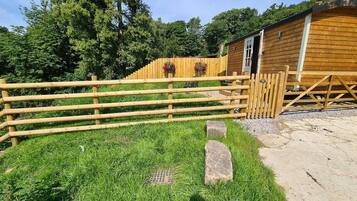 A wooden fence, a grassy area, and a building with a door.