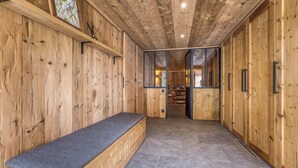 A wooden interior with a bench, a glass door leading to another room, and a tiled floor. - Chalet Birdie + Mazot: elegant and spacious property in Les Houches (Les Houches)