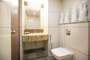 Um banheiro com pia, espelho, vaso sanitário e porta-toalhas.