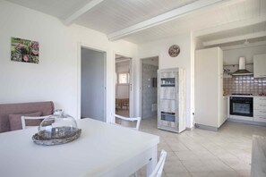 A modern kitchen with white cabinets, a built-in oven, and a tiled backsplash.
