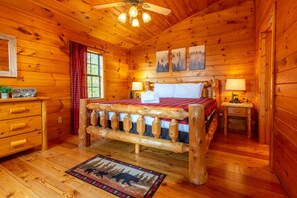 A wooden cabin bedroom with a bed, two bedside tables, a dresser, and a ceiling fan. - Amazing Mountain View Cabin with Jacuzzis, Hot Tub & StarlinkWIFI! Pets Welcome! (Sevierville)