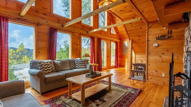A cozy cabin interior with a sofa, coffee table, and a fireplace.