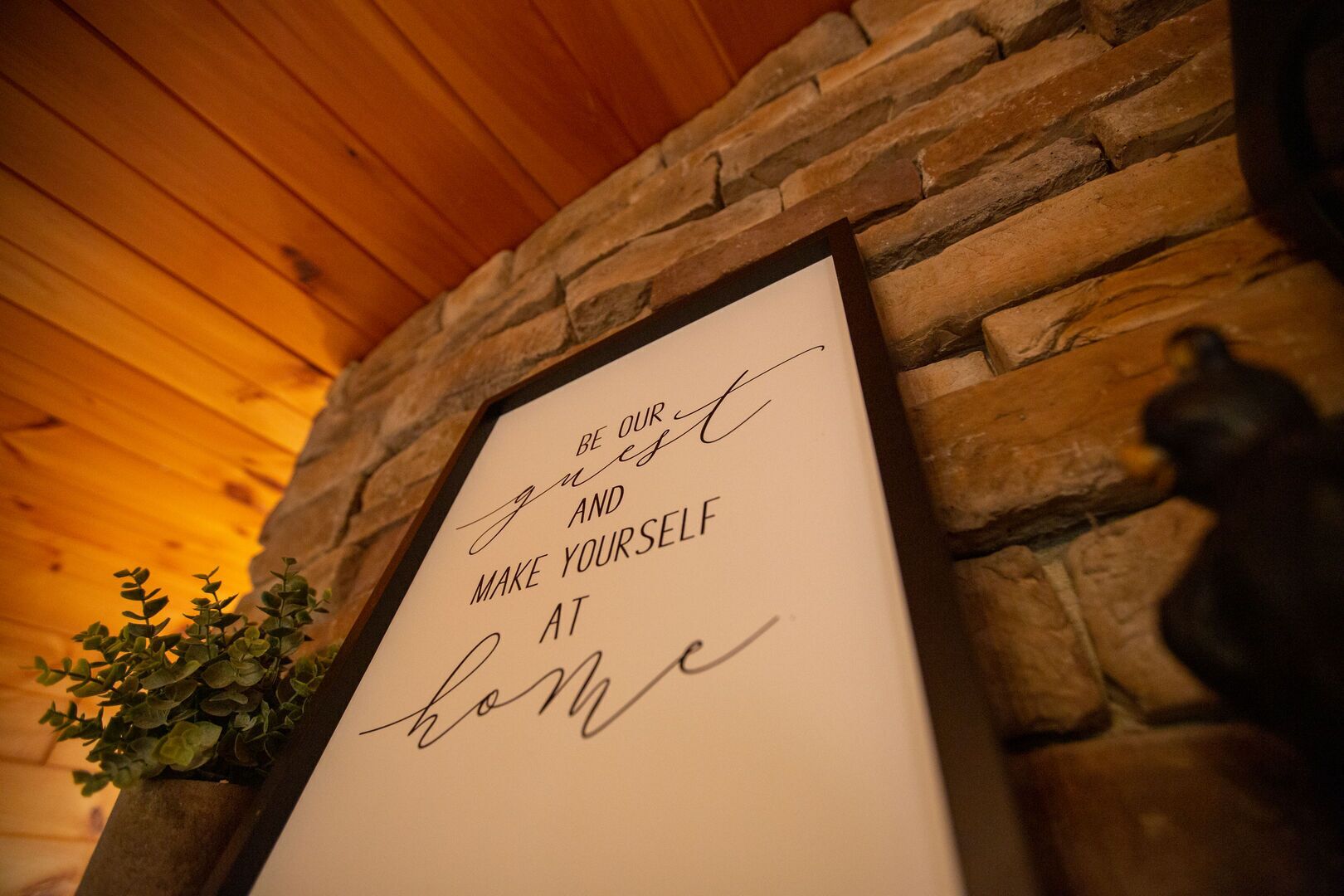 A framed inspirational quote on a stone wall.