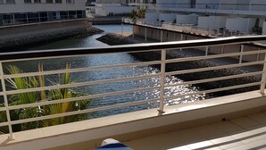 A balcony with two blue sun loungers, a small water feature, and a view of modern buildings. - Spacious Marina Apartment lovely balcony view, near to pool, WiFi & UK Tv (Lagos)