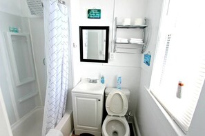 Bathtub, hair dryer, towels, shampoo