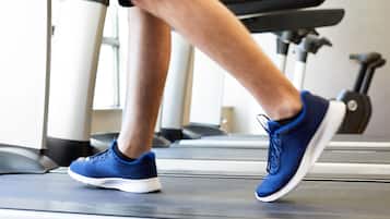 Ein Laufband im Fitnessstudio, auf dem eine Person joggt.