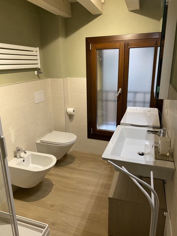 A bathroom with a toilet, bidet, and sink.