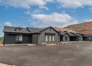 A modern two-story house with a large driveway and a mountain backdrop. - BLACK SHEEP INN Newly Constructed Merino #1 of 4 Units (Cedar City)