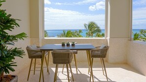 A balcony with a table and chairs, a potted plant, and a view of the ocean. - Breathless 4You, Oceanfront Penthouse (Cap Cana)