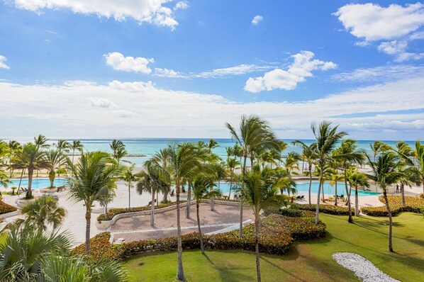 A resort with a pool, palm trees, and a view of the ocean. - Breathless 4You, Oceanfront Penthouse (Cap Cana)