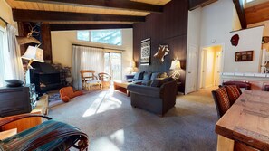 A cozy living room with a fireplace, comfortable seating, and a dining area.
