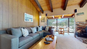 A cozy living room with a sectional sofa, a wooden coffee table, and a fireplace. - Chateau Blanc 25 Cozy with Gorgeous Mountain Views, On the Shuttle Route, by RedAwning (Mammoth Lakes)