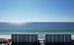 A hotel with a Seachase sign, a pool, and a view of the ocean.