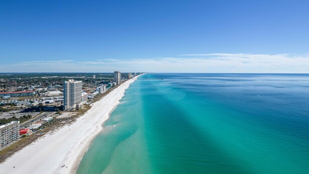 A coastal cityscape with a long beach, clear blue waters, and high-rise buildings along the shore. - FREE Beach Service for 2, FREE Daily Golf & Perks! Beachfront Seachase E802 (Panama City Beach)