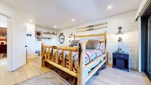 A wooden bed with a headboard, a bedside table, and a wall-mounted lamp. - Bridges Townhome 5 Large, Remodeled Mountain View Townhome with Private Jacuzzi, Steps to Eagle Lodge by RedAwning (Mammoth Lakes)