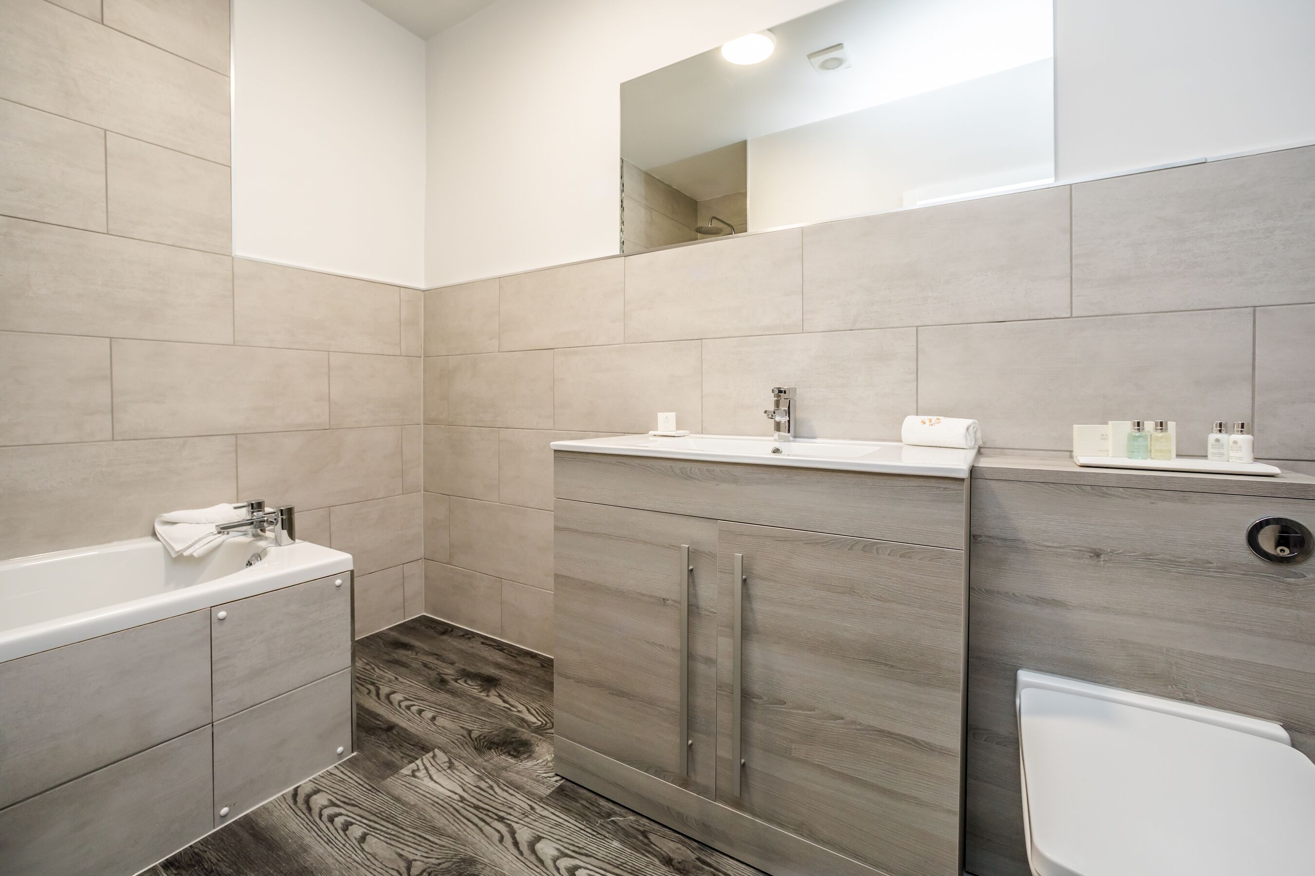 Un baño moderno con bañera, tocador e inodoro.