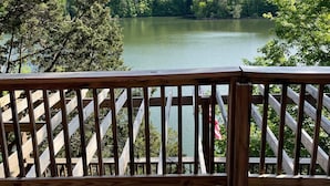 Un pontile in legno con ringhiera che si affaccia su un lago circondato da alberi.