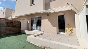 A modern building with a flat roof, large windows, and a covered entrance area. - Villa en Location Près des Plages (Saint-Brès)
