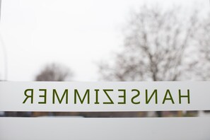 Un letrero con la palabra "HANSIMISAN" en letras verdes sobre un fondo blanco.