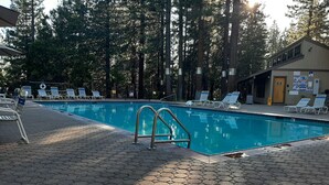 A swimming pool with lounge chairs and a lifeguard stand.