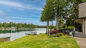 A lakeside property with a dock, a gazebo, and a well-maintained lawn.