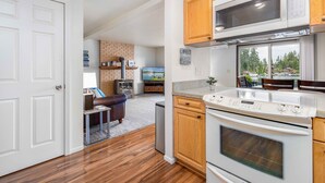 A modern kitchen with a built-in microwave, oven, and wooden cabinets.