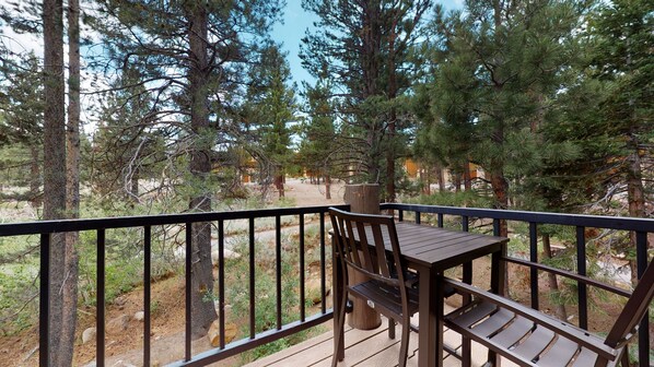 Guests can enjoy a peaceful seating area on this deck overlooking the forest.